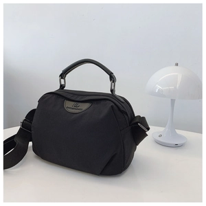 Dettaglio borsa a tracolla in nylon nero minimalista con tracolla regolabile e logo