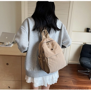 Detailed back view of a khaki lightweight nylon backpack with multi-layer zippers