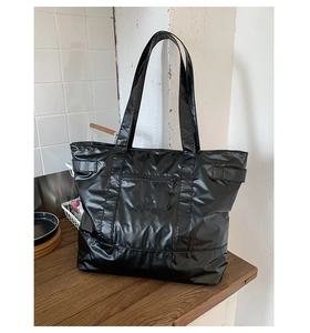 Détail du sac cabas en nylon noir imperméable avec poche zippée et broderie du logo