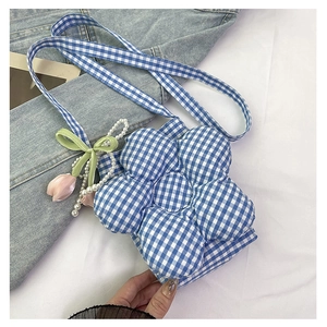 Close-up of flower-shaped checkered crossbody bag with pearl and tulip charm details