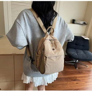 Detail of a lightweight beige nylon backpack with comfortable wide shoulder straps