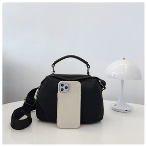 Confronto dimensioni della borsa in nylon con uno smartphone su uno sfondo sobrio