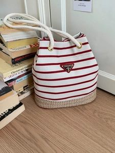 Borsa a secchiello in tela a righe con base in paglia intrecciata e manico in corda