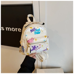 Détail d'un mini sac à dos blanc avec des imprimés graffiti et un nœud décoratif