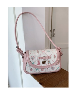 Detail of pink bow and heart pendant on ballet style crossbody bag with cute prints