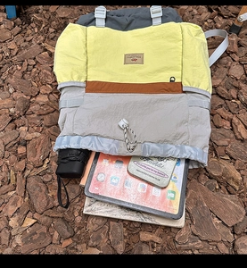 Detail view of the spacious interior of this tricolor backpack holding a tablet and umbrella
