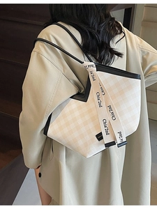 Fashionable checkered tote bag in cream and black with stylish logo strap for daily commute