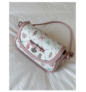 Detail view of pink ballet-style crossbody bag with cute cartoon prints and bow