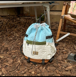 Detail of color-block drawstring backpack with waterproof nylon fabric and leather brand tag