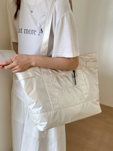 Grand sac cabas minimaliste blanc crème avec broderie porté par un mannequin
