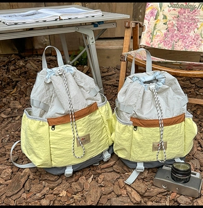 Detail view of large drawstring bucket backpacks in vibrant color block nylon material