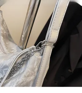 Detail of silver metallic tote bag with lobster clasp and chain strap connection