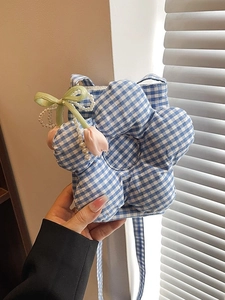 Blue gingham floral crossbody bag with pearl handle and tulip charms shown in hand