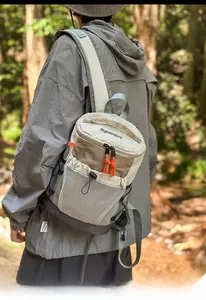 Outdoor leisure crossbody bag with mesh pocket and orange zippers in forest setting