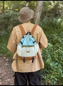 Detailed view of color-block drawstring backpack with adjustable brown wide shoulder straps