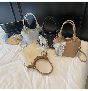 Détails de quatre sacs seaux en plusieurs couleurs avec breloques en dentelle et poignées