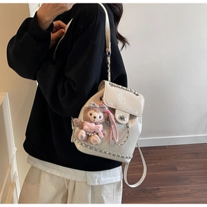 Detailansicht weißer Rucksack aus Lackleder mit Silberketten und einem Plüschbär-Anhänger