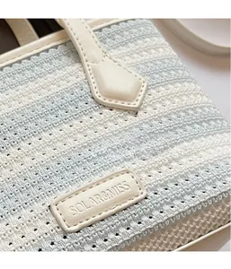 Close-up of blue and white woven texture on tote bag with leather logo detail