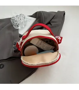 Interior view of small red canvas bowling bag showing storage for phone and cosmetics