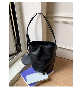 Detail der schwarzen PU-Zylinder-Tasche mit Knotengurt und rundem Münzfach-Accessoire