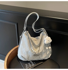 Détail du sac cabas plissé argenté avec chaîne en perles et breloque nuage blanc