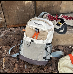 Detailed outdoor view of a lightweight multi-color trekking backpack with mesh pocket