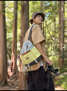 Detail of gray and yellow drawstring backpack made of ripstop nylon for outdoor hiking