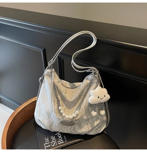 Détails du sac argenté avec chaîne épaisse, perles et pendentif nuage en peluche