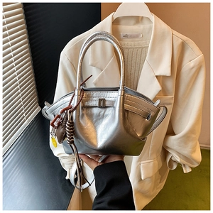 Detailed view of a silver metallic hobo bag with pleated texture and decorative pendant