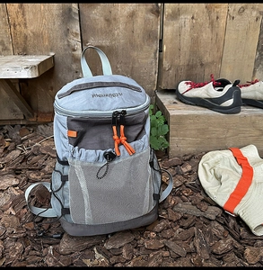 Detail of outdoor backpack with front mesh pocket and vibrant orange zipper accents