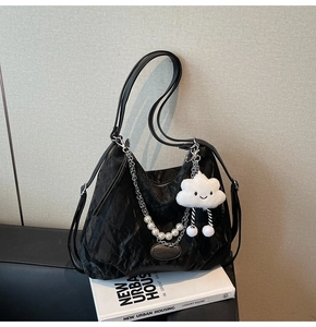 Détail du sac cabas plissé noir avec chaîne en perles et breloque nuage en peluche