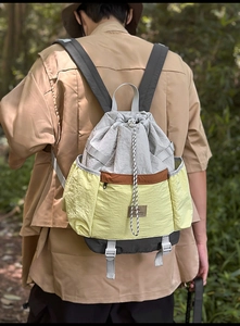 Outdoor shot showing tricolor hiking backpack with drawstring and durable nylon fabric