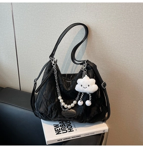 Détail du sac cabas plissé noir avec chaîne en perles et charme nuage en peluche