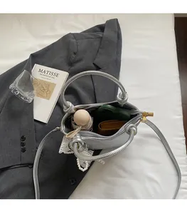 Intérieur spacieux du sac seau en cuir argenté avec rangement pour parapluie et mobile