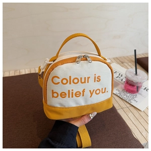 Detail view of the yellow canvas patchwork bowling bag with silver zipper and printed text