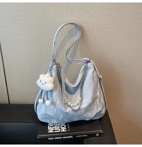 Détail du cabas plissé bleu clair avec chaîne de perles et pendentif nuage doux