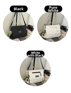 Detailed view of large messenger bags in black and white with green dinosaur charms