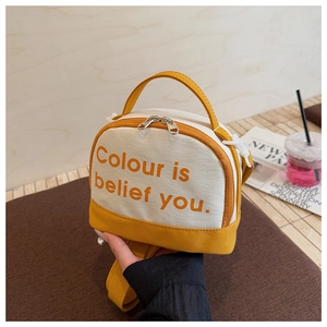 Detail of canvas bowling bag with yellow leather trim and orange typography print