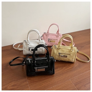 Primer plano de mini bolsos Boston blancos, rosas, amarillos y negros con plata
