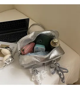 Interior view of spacious silver metallic hobo bag with daily essentials and bow charms