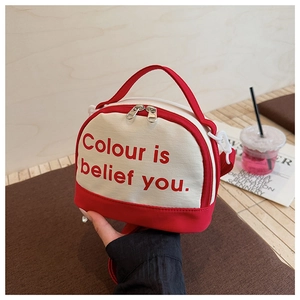 Close-up of the red and beige bowling bag with contrast top handle and zipper closure