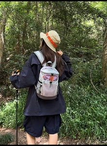 Outdoor hiking backpack with purple and grey color block design shown in forest scenery