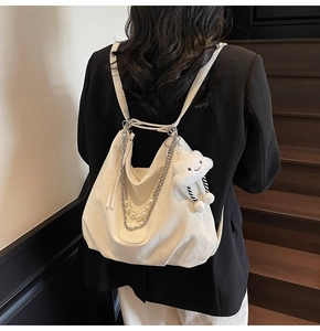 Détail du sac hobo plissé blanc avec chaîne argentée, perles et breloque peluche