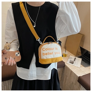 Close-up of a stylish yellow and white canvas bowling bag with slogan and shoulder strap