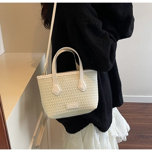 Model showing a knit bucket bag with detachable strap and off-white woven texture