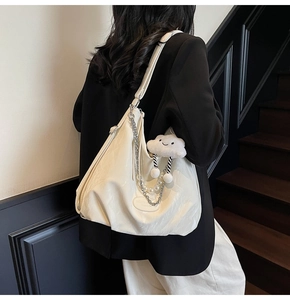 Detailed view of white pleated leather tote with pearl chain and cloud charm detail