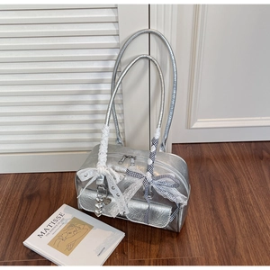 Detail of silver metallic bag with pleated texture, lace bows and heart charms