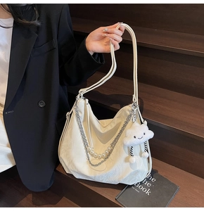 Détail du grand sac cabas blanc cassé avec chaîne argentée, perles et breloque nuage