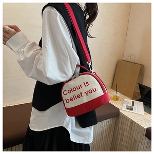 Detail of a red and white canvas bowling bag with double zippers and fabric strap