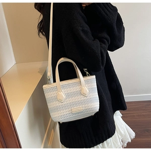Detailed knit texture of off-white woven bucket bag with elegant Polaris gold logo